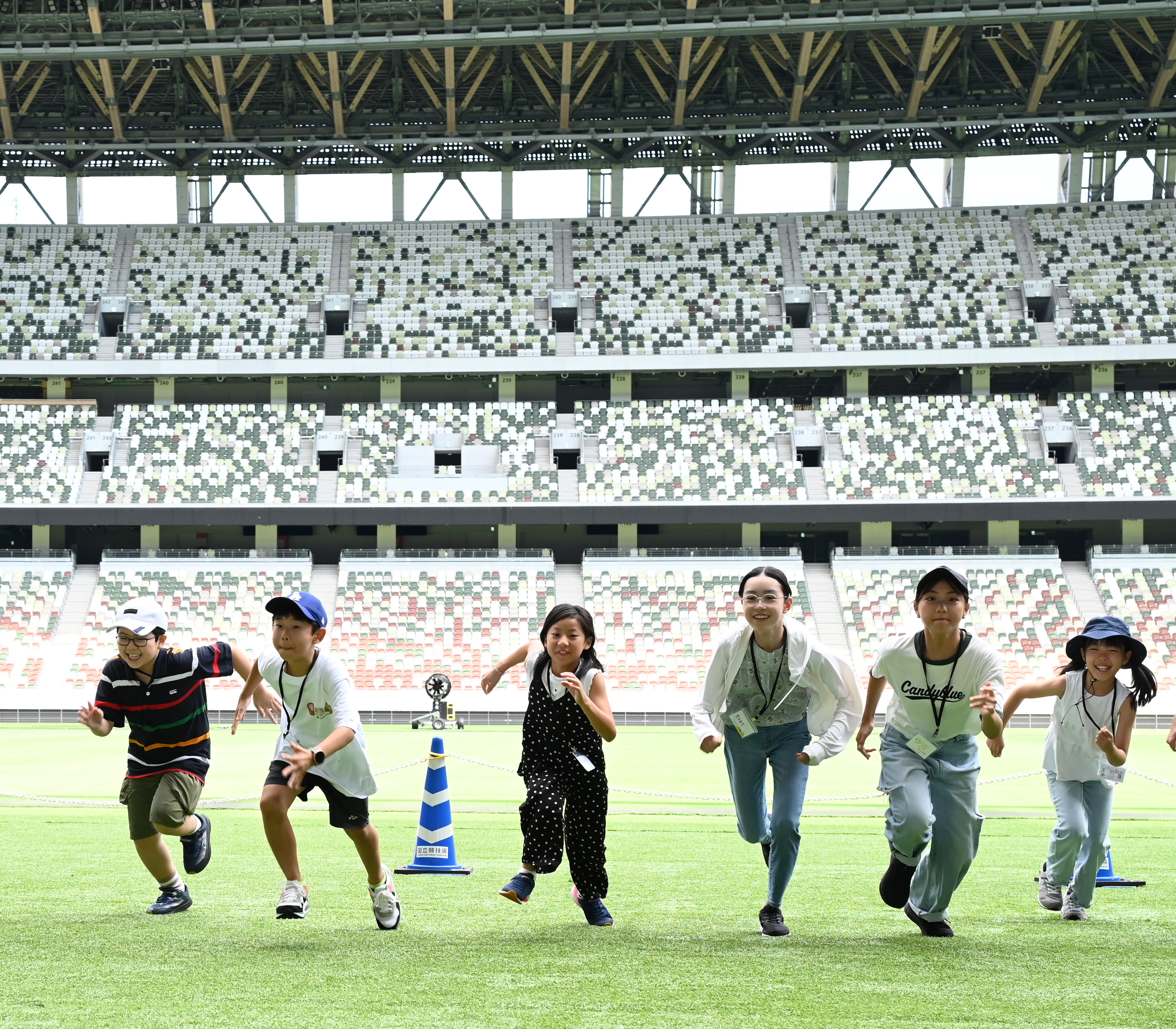 子供6人が国立競技場で走っている写真